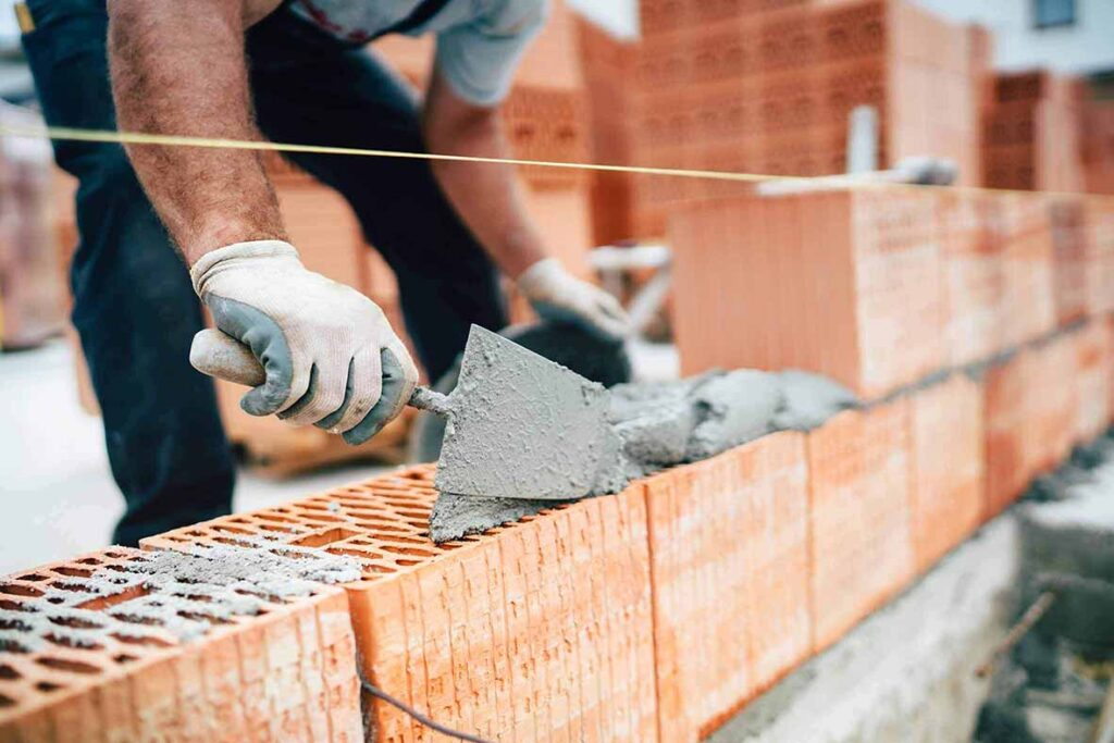 Dicas para pedreiro experiente trabalhando em uma obra, utilizando ferramentas e técnicas adequadas